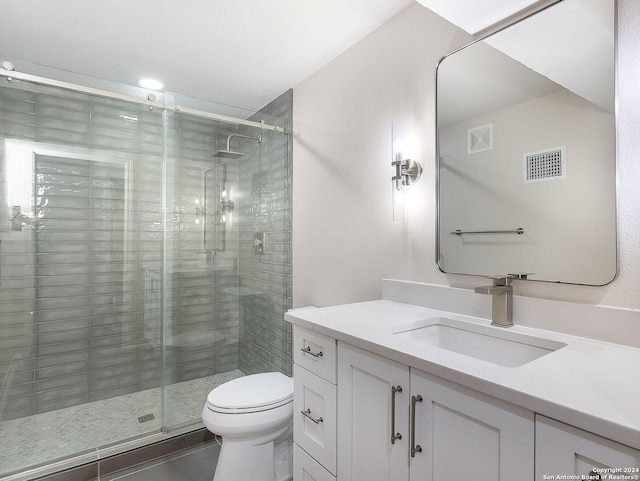 bathroom featuring a shower with door, toilet, and vanity