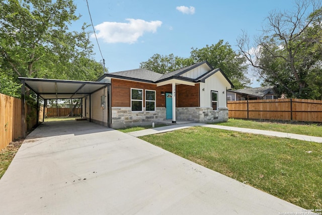 view of front of property featuring a front yard and a carport