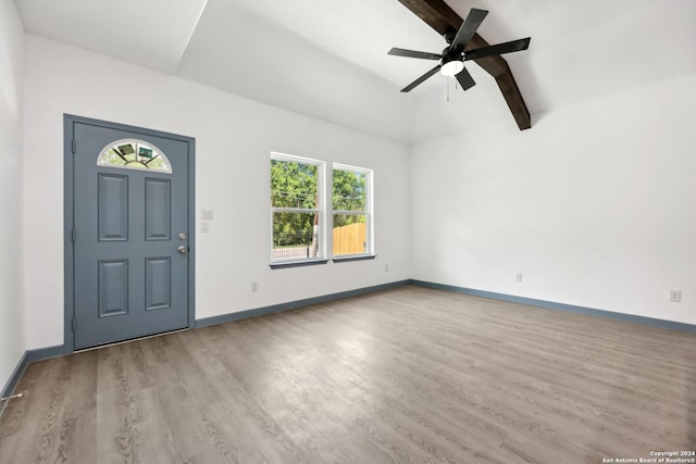 foyer entrance with a wealth of natural light, lofted ceiling with beams, ceiling fan, and light wood-type flooring