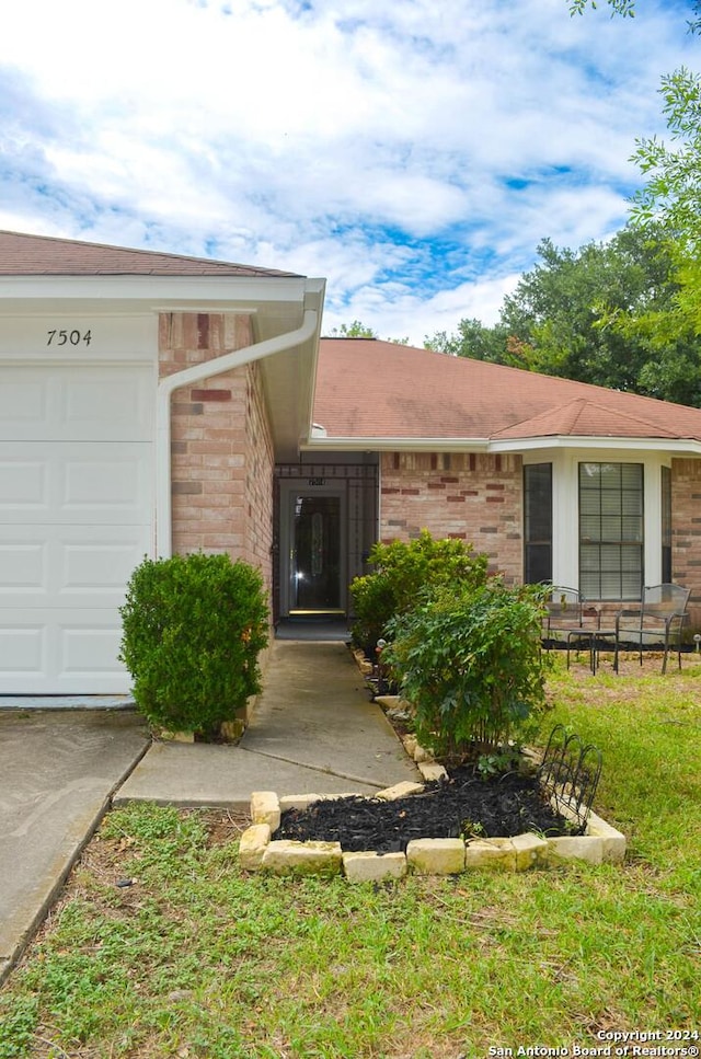 doorway to property featuring a garage and a yard