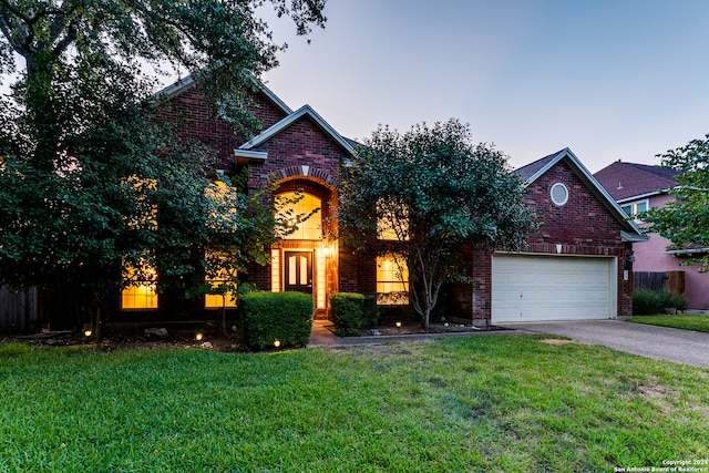 view of property with a garage and a lawn