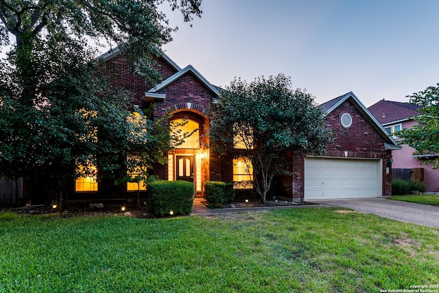 view of front of house with driveway, an attached garage, fence, a front lawn, and brick siding