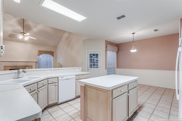 kitchen featuring white dishwasher, light tile patterned flooring, sink, pendant lighting, and a center island