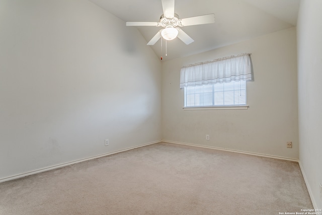 empty room featuring vaulted ceiling, light colored carpet, and ceiling fan