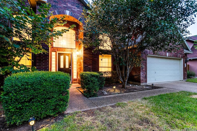 view of front of home with concrete driveway, brick siding, and an attached garage