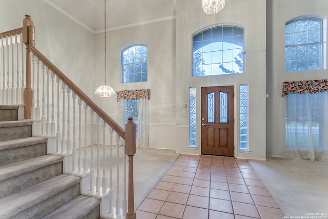 foyer entrance with carpet floors, a chandelier, and a high ceiling