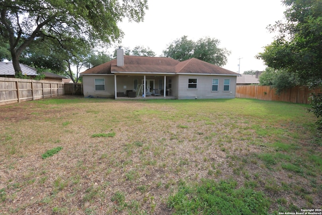 back of property with a lawn