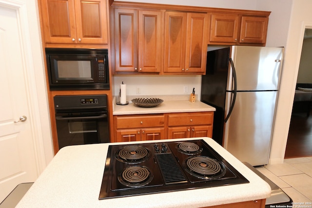 kitchen with black appliances and light tile patterned floors