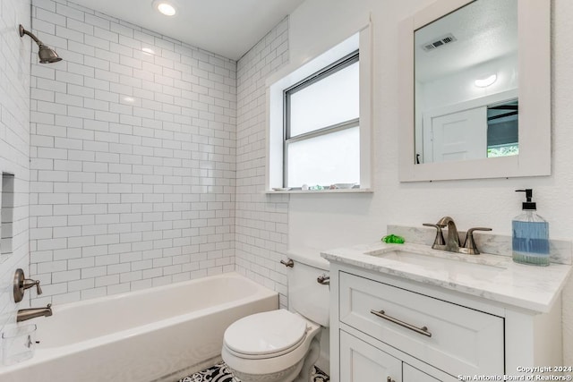 full bathroom featuring toilet, vanity, and tiled shower / bath