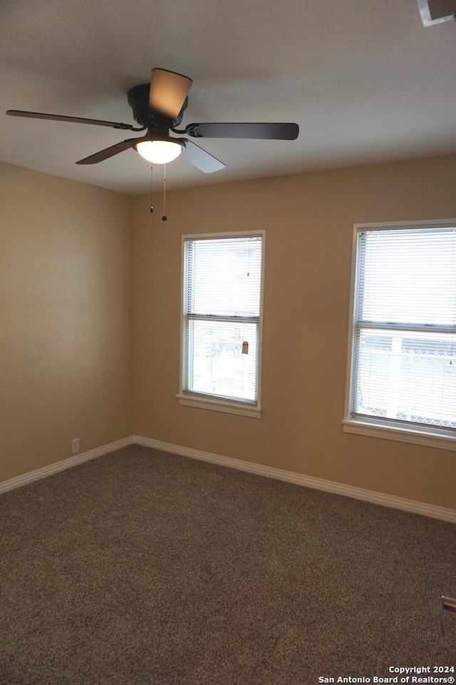 carpeted spare room with ceiling fan