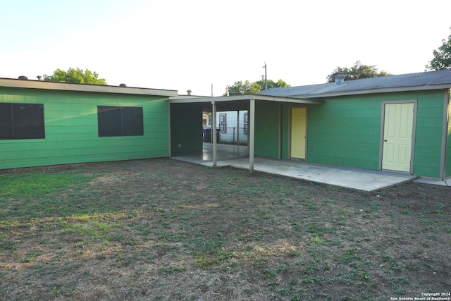 back of property featuring a patio area and a lawn