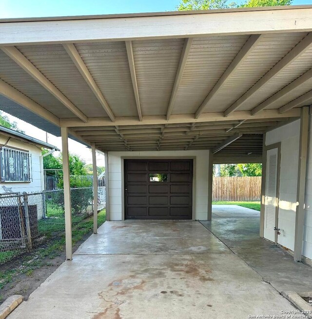 411 W Hart Ave, San Antonio, TX 78214 - garage featuring fence and an attached carport