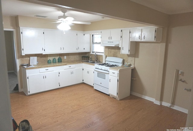 kitchen with light hardwood / wood-style floors, decorative backsplash, white cabinets, sink, and gas range gas stove