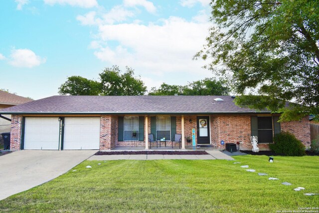 ranch-style home with covered porch, a garage, and a front lawn