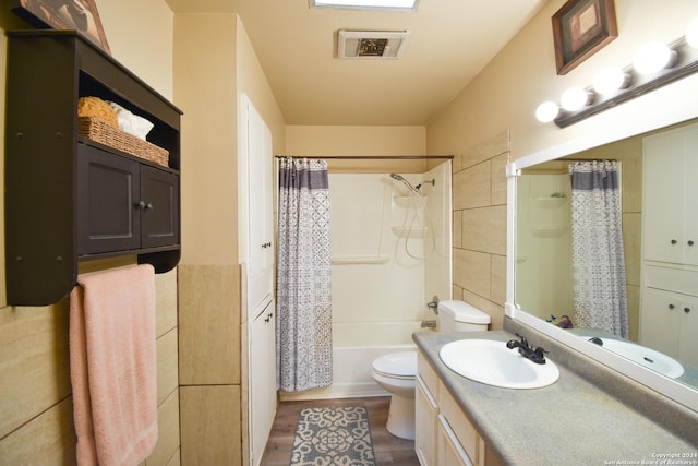 full bathroom with shower / tub combo, vanity, wood-type flooring, and toilet