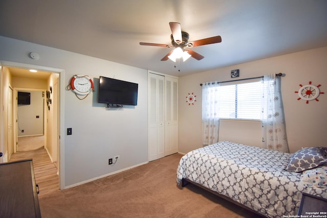 carpeted bedroom featuring ceiling fan and a closet