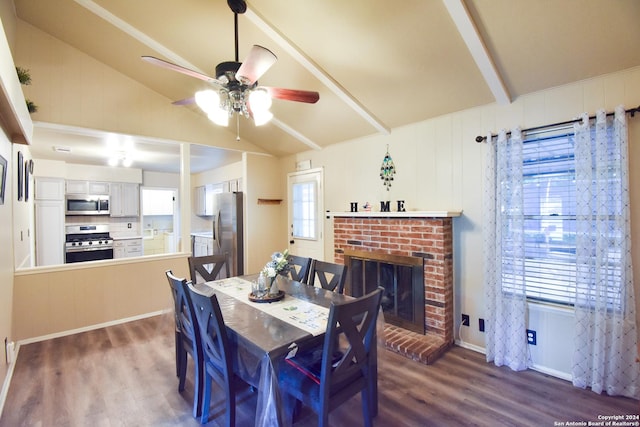 dining room featuring dark hardwood / wood-style flooring, a fireplace, lofted ceiling with beams, and ceiling fan