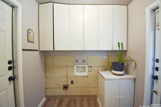 washroom featuring dark wood-type flooring, cabinets, washer hookup, and hookup for an electric dryer