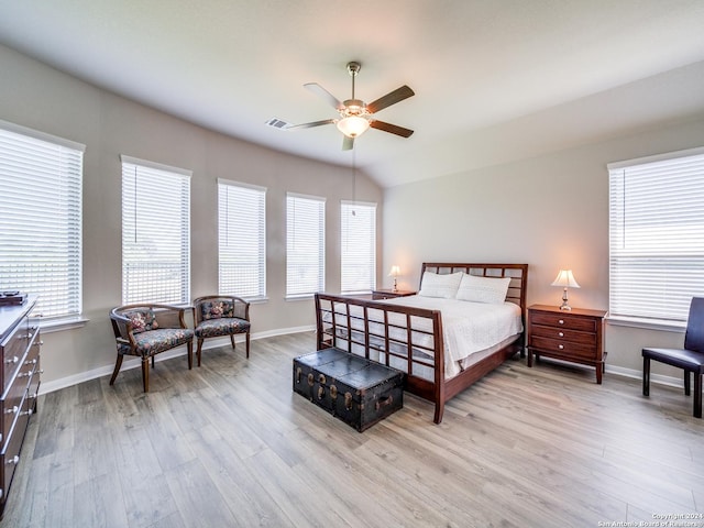 bedroom with light wood finished floors, visible vents, a ceiling fan, vaulted ceiling, and baseboards