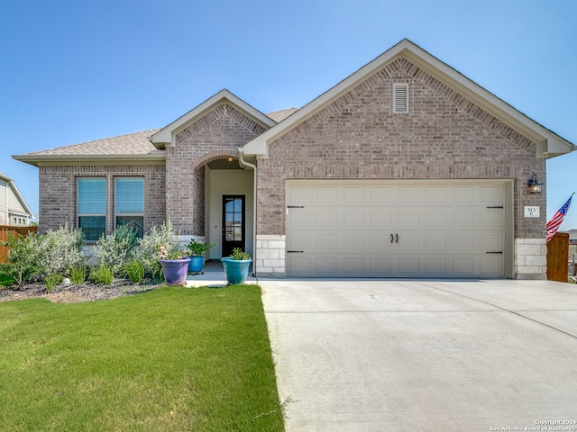 view of front of home with a garage and a front lawn