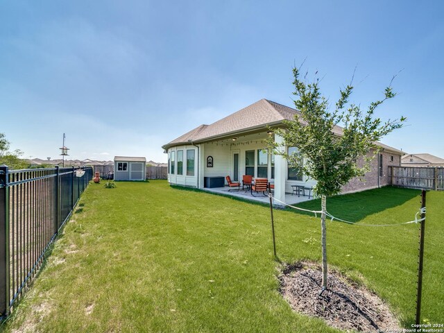 rear view of property with a patio, an outdoor structure, and a yard