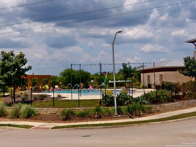 view of community with a pergola, a pool, and playground community