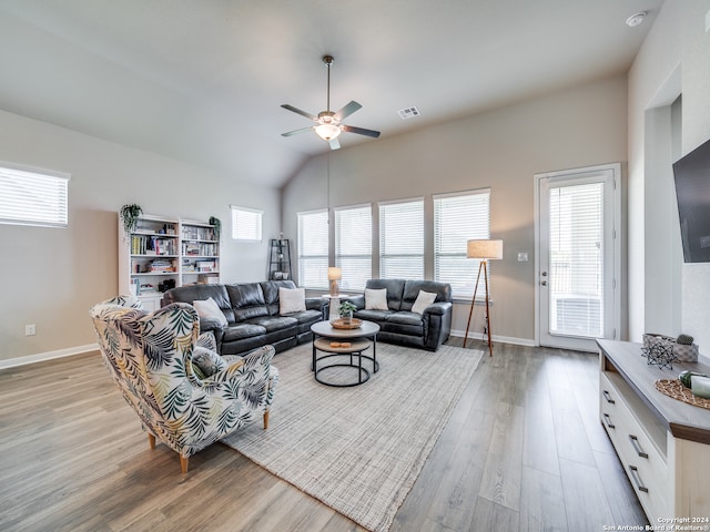 living room featuring vaulted ceiling, light hardwood / wood-style flooring, and ceiling fan