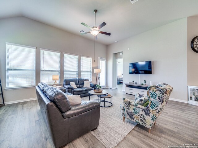 living room featuring ceiling fan, wood-type flooring, and vaulted ceiling