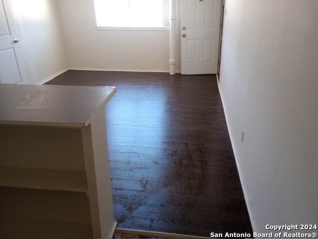 unfurnished room featuring dark wood-type flooring