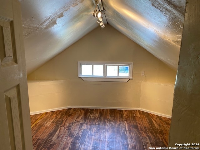 additional living space featuring lofted ceiling and hardwood / wood-style floors