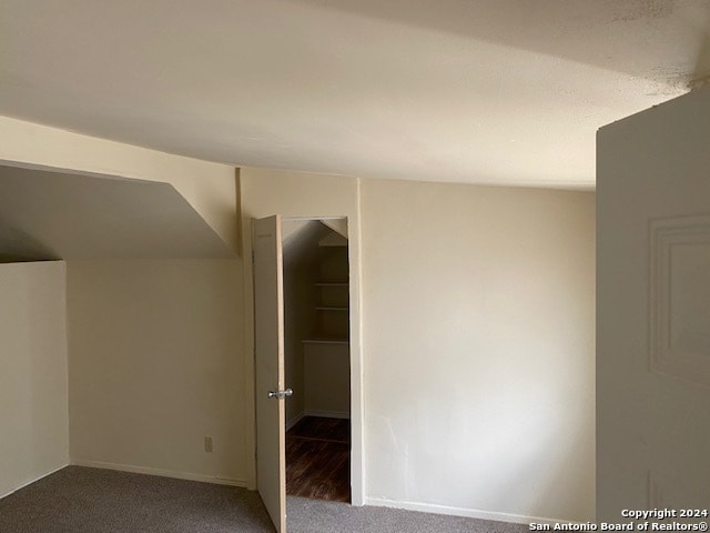 interior space featuring vaulted ceiling and carpet floors