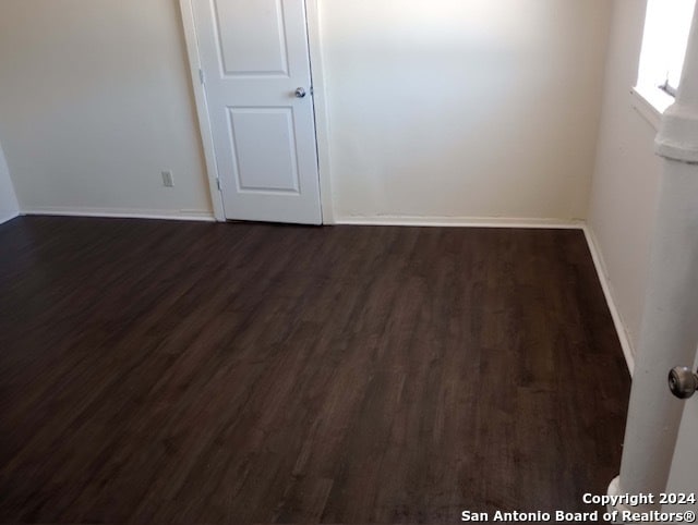 spare room with dark wood-type flooring