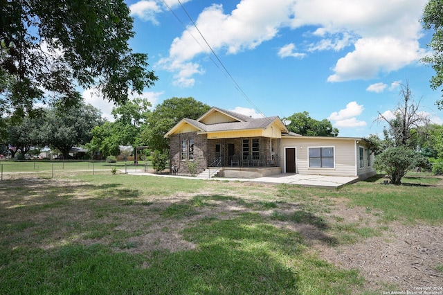 back of house featuring a patio area and a lawn