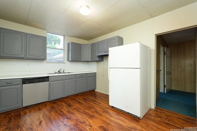 kitchen with gray cabinets, a drop ceiling, dark hardwood / wood-style flooring, and white appliances