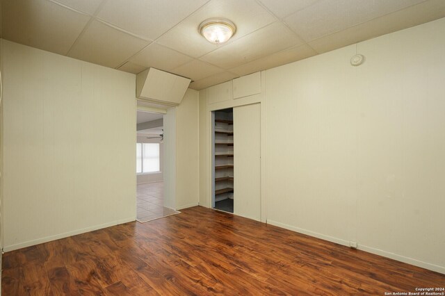 unfurnished room with a paneled ceiling and hardwood / wood-style flooring