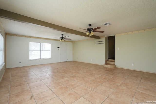 tiled spare room featuring an AC wall unit, beamed ceiling, a textured ceiling, and ceiling fan