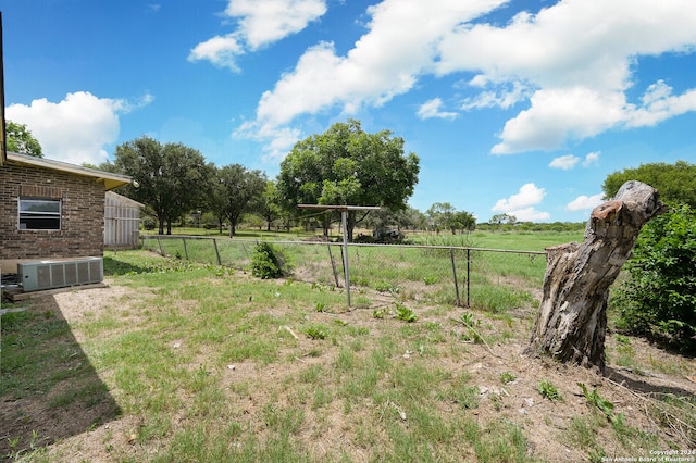 view of yard with central AC and a rural view