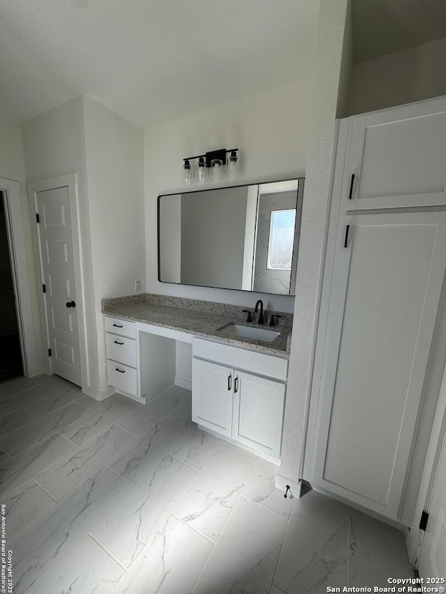 bathroom featuring marble finish floor and vanity