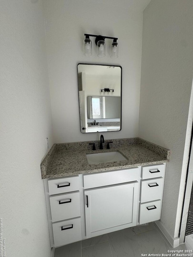 bathroom featuring marble finish floor and vanity