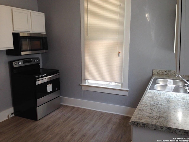 1633 W Woodlawn Ave, San Antonio, TX 78201 - kitchen with stainless steel appliances, a sink, white cabinets, dark wood-style floors, and baseboards
