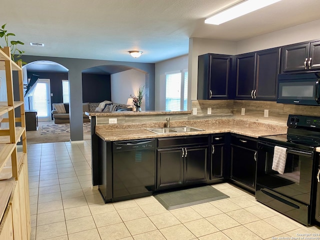 kitchen with sink, light colored carpet, black appliances, and kitchen peninsula