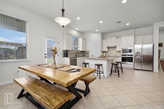 dining space featuring light tile patterned floors and sink