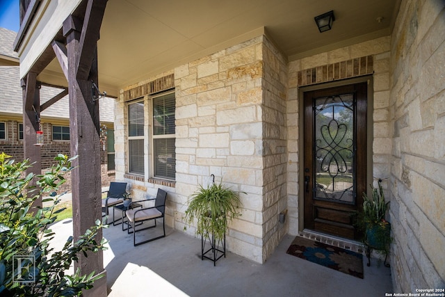 property entrance featuring covered porch and stone siding