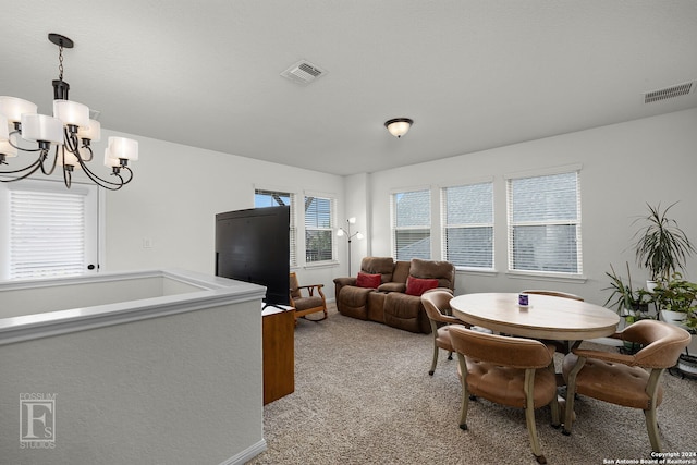 carpeted dining area featuring an inviting chandelier