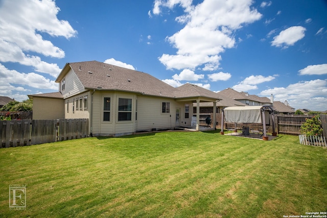 rear view of property with a yard and a patio