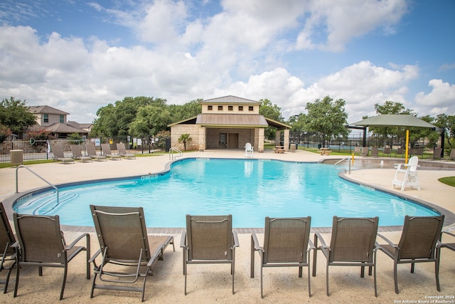 view of swimming pool featuring an outbuilding and a patio