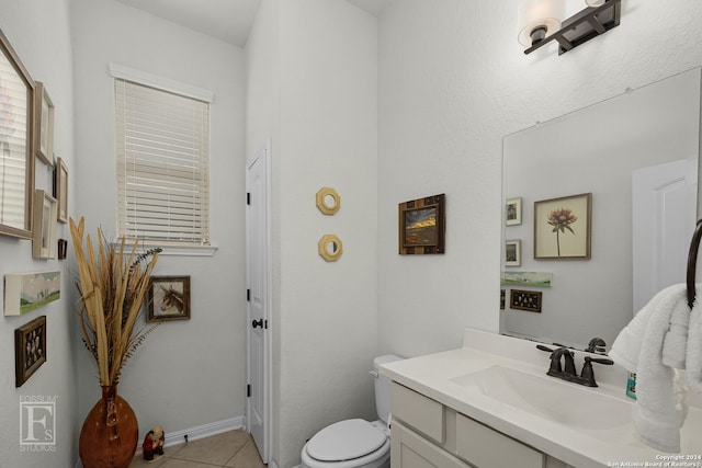 bathroom with toilet, vanity, and tile patterned floors