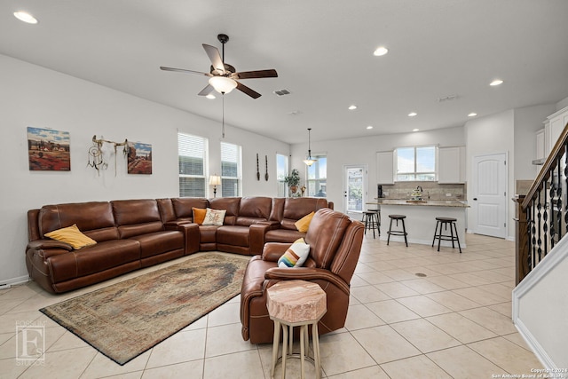 tiled living room featuring plenty of natural light, ceiling fan, and sink