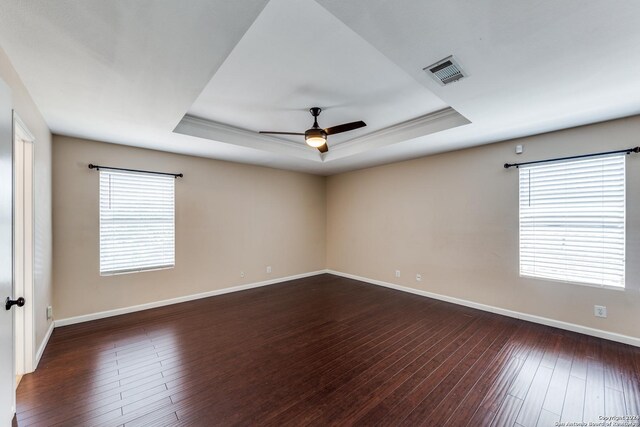 empty room featuring ceiling fan, hardwood / wood-style floors, and a tray ceiling