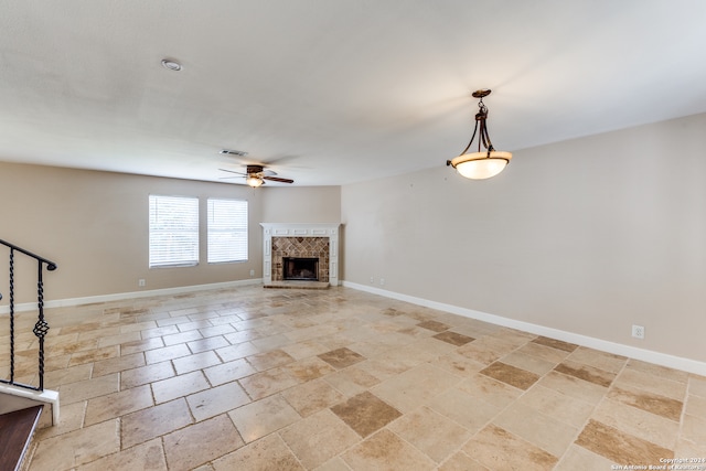 unfurnished living room with a fireplace, light tile patterned floors, and ceiling fan